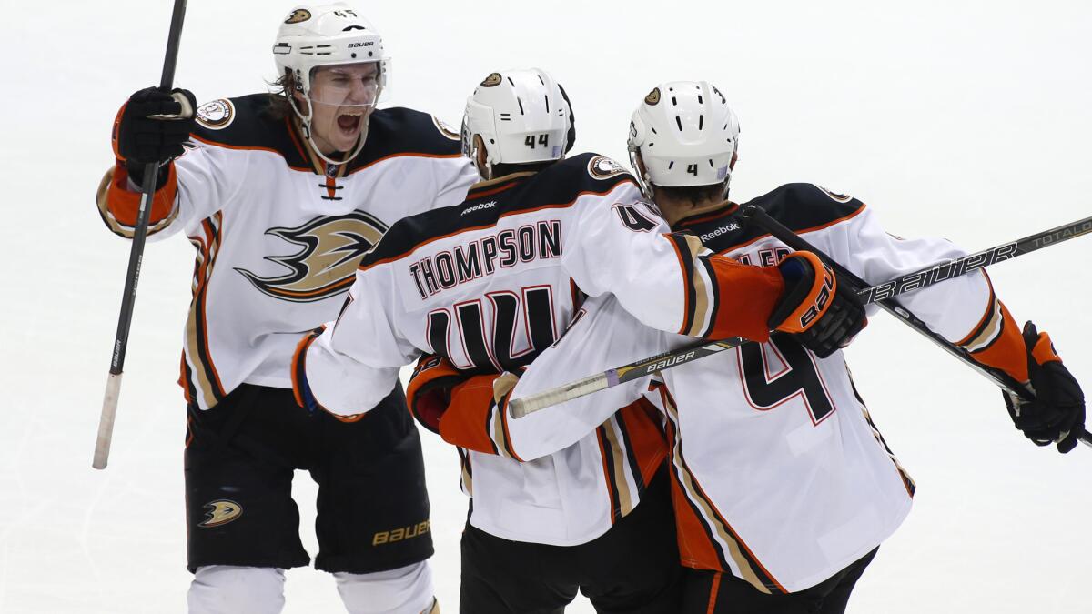 Ducks center Nate Thompson, middle, celebrates with teammates Sami Vatanen, left, and Cam Fowler after scoring the winning goal in a 2-1 overtime victory over the Dallas Stars on Friday.