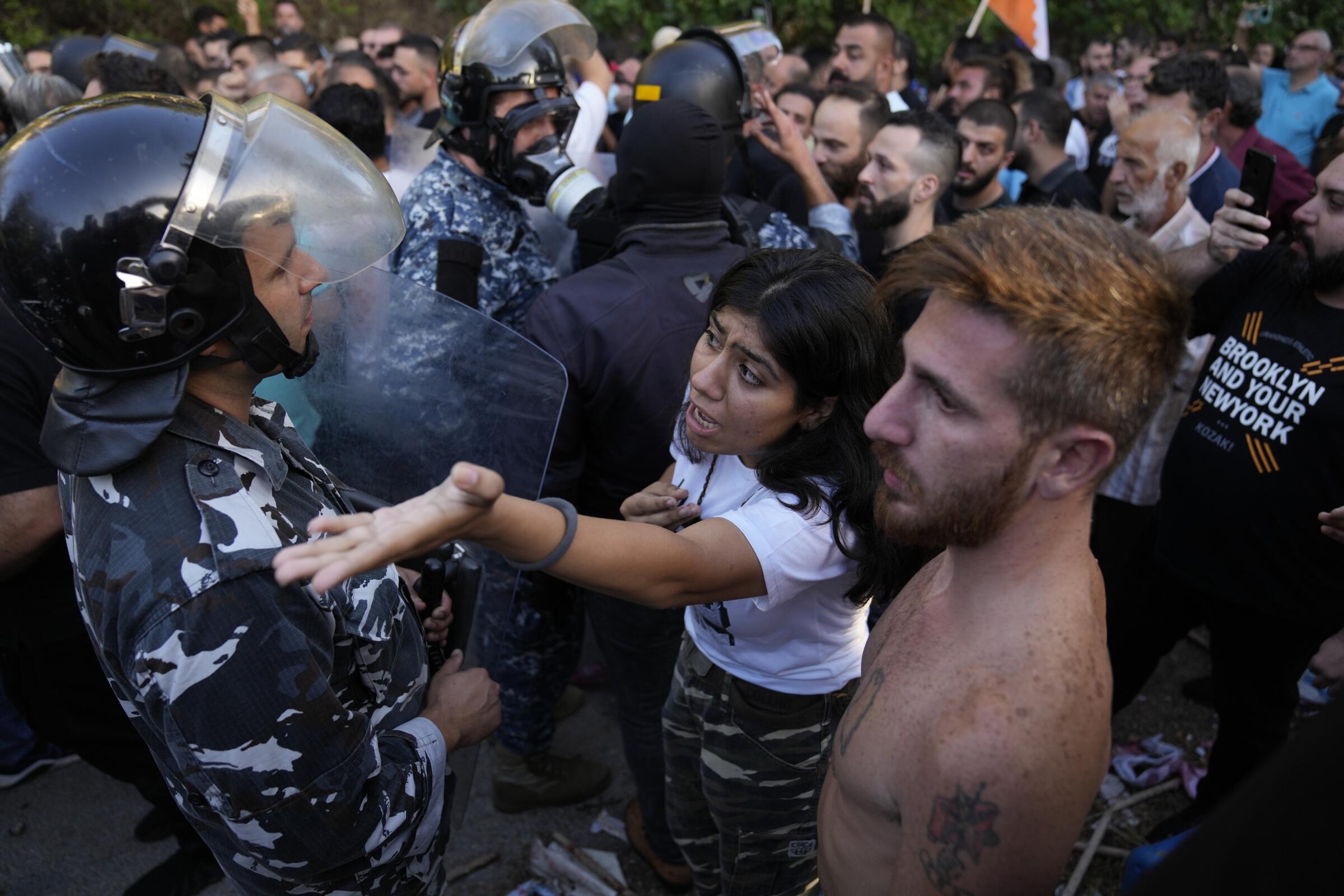 People in helmets and uniforms face another group of people.