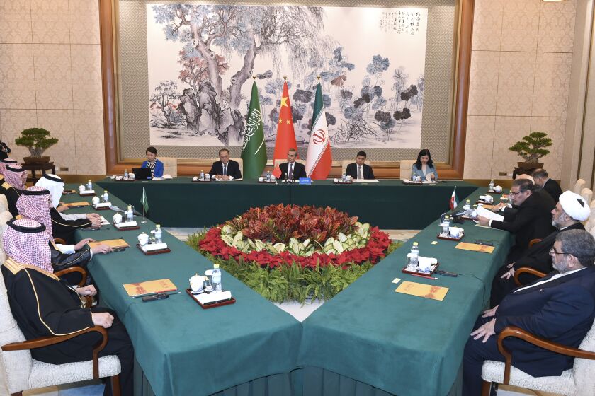In this photo released by Xinhua News Agency, Wang Yi, China's most senior diplomat, center, presides over a closed meeting between Iran, led by Ali Shamkhani, the secretary of Iran's Supreme National Security Council, at right, and Saudi Arabia, led by Saudi national security adviser Musaad bin Mohammed al-Aiban, at left, in Beijing, Saturday, March 11, 2023. Iran and Saudi Arabia agreed Friday to reestablish diplomatic relations and reopen embassies after seven years of tensions. The major diplomatic breakthrough negotiated with China lowers the chance of armed conflict between the Mideast rivals, both directly and in proxy conflicts around the region. (Luo Xiaoguang/Xinhua via AP)