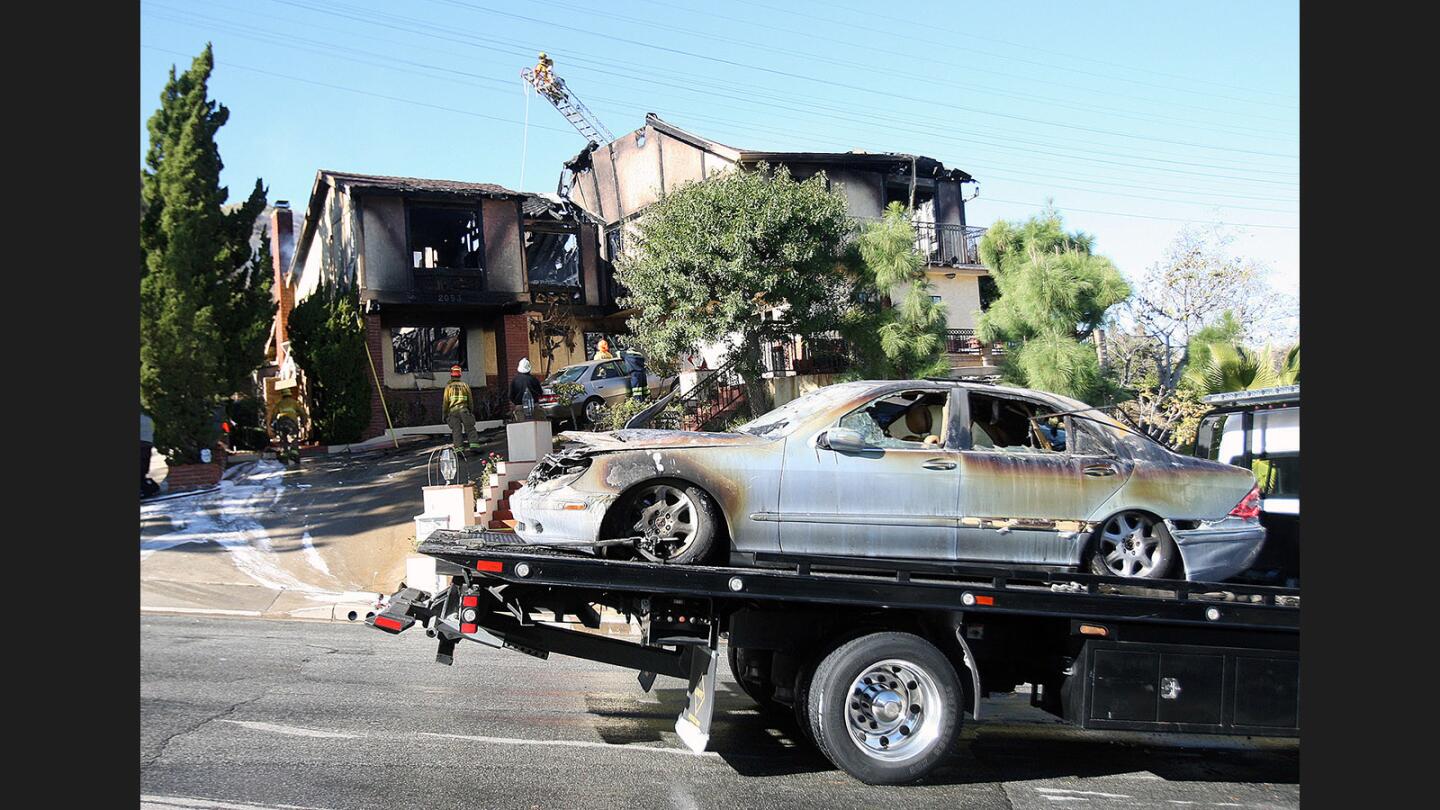 A Mercedes Benz destroyed by a house fire in Glendale is towed away from the scene on Monday, Dec. 19, 2016. Three Glendale police officers were the first to respond to the blaze on the 2000 block of Dublin Drive at 5:17 a.m. Using a neighbor's ladder, they were able to rescue a woman from a second-floor balcony. The officers and the woman were transported to a nearby hospital for minor injuries.