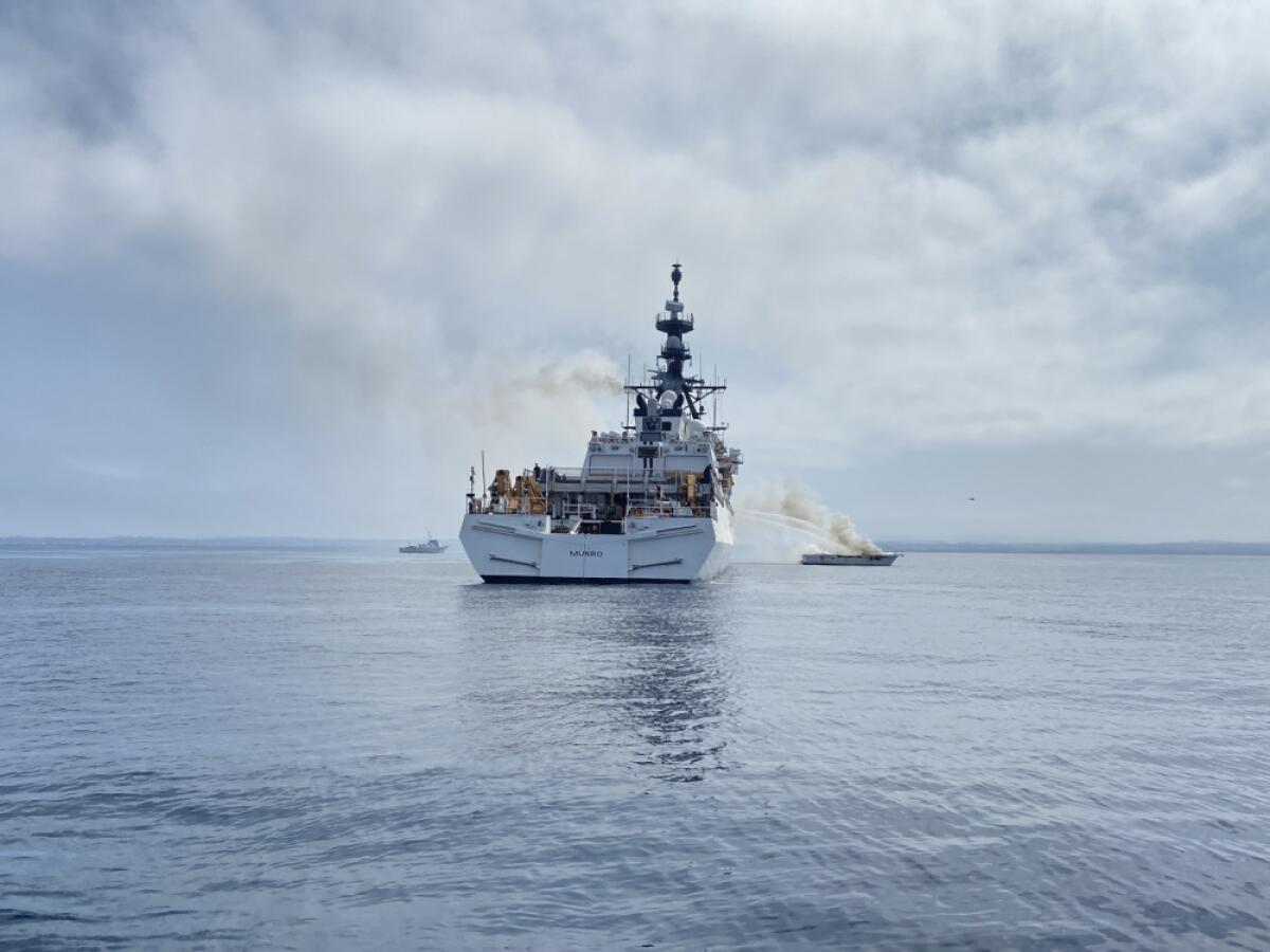 Coast Guard cutter dousing smaller boat with water