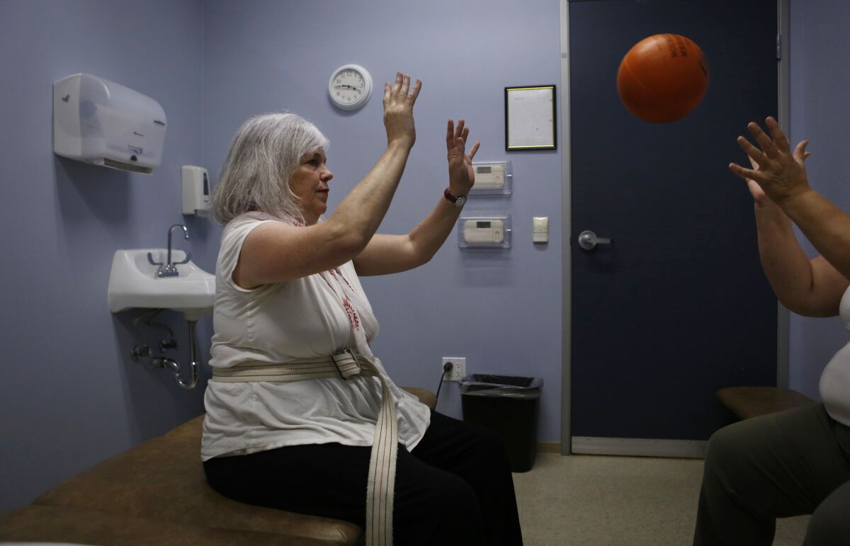 Missy throws a weighted ball back and forth with her physical therapist during her weekly PT appointment at Huntington Rehab Med Associates in Pasadena.