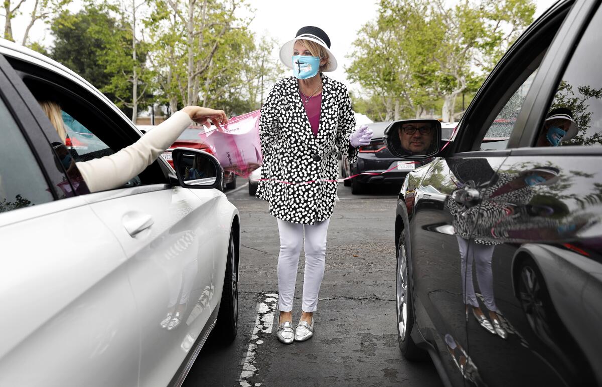 MaryAnn Lawson collects prayer requests from people gathering in their cars for a drive-in service in Santa Ana.