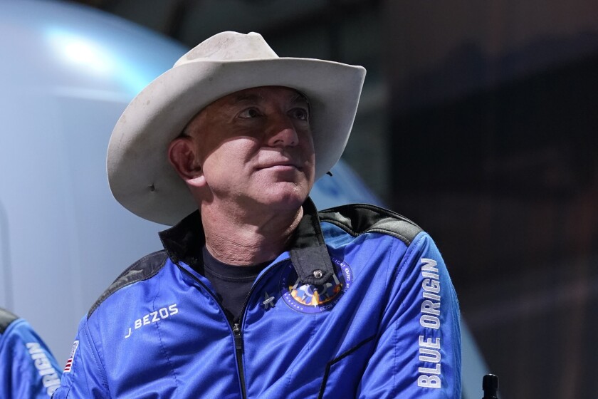 Amazon founder Jeff Bezos shown in a gray cowboy hat and blue jacket that reads 'Blue Origin'