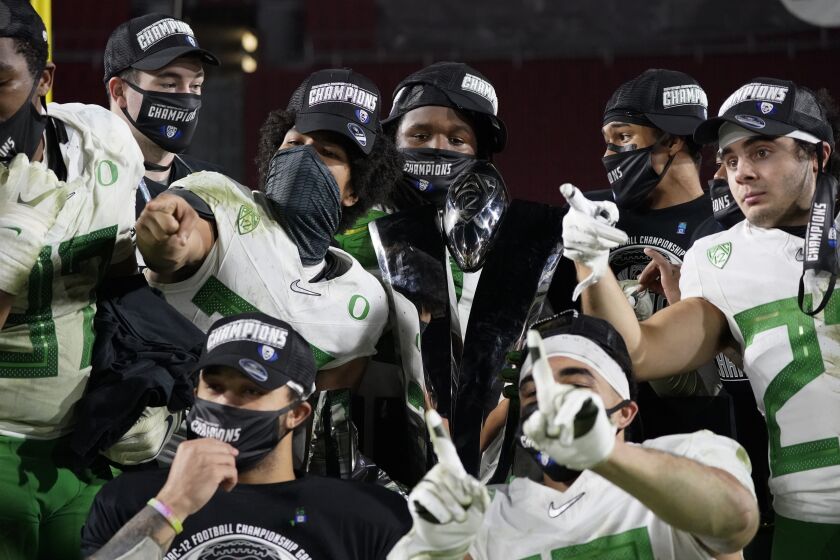 Oregon football players celebrate after winning an NCAA college football game for the Pac-12 Conference championship against Southern California Friday, Dec 18, 2020, in Los Angeles. (AP Photo/Ashley Landis)