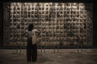 A visitor observes an artwork in a museum