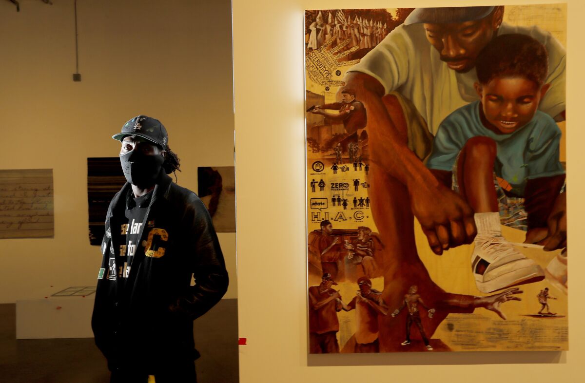 ShowzArt stands beside his untitled artwork at the We Rise pop-up gallery in downtown L.A.