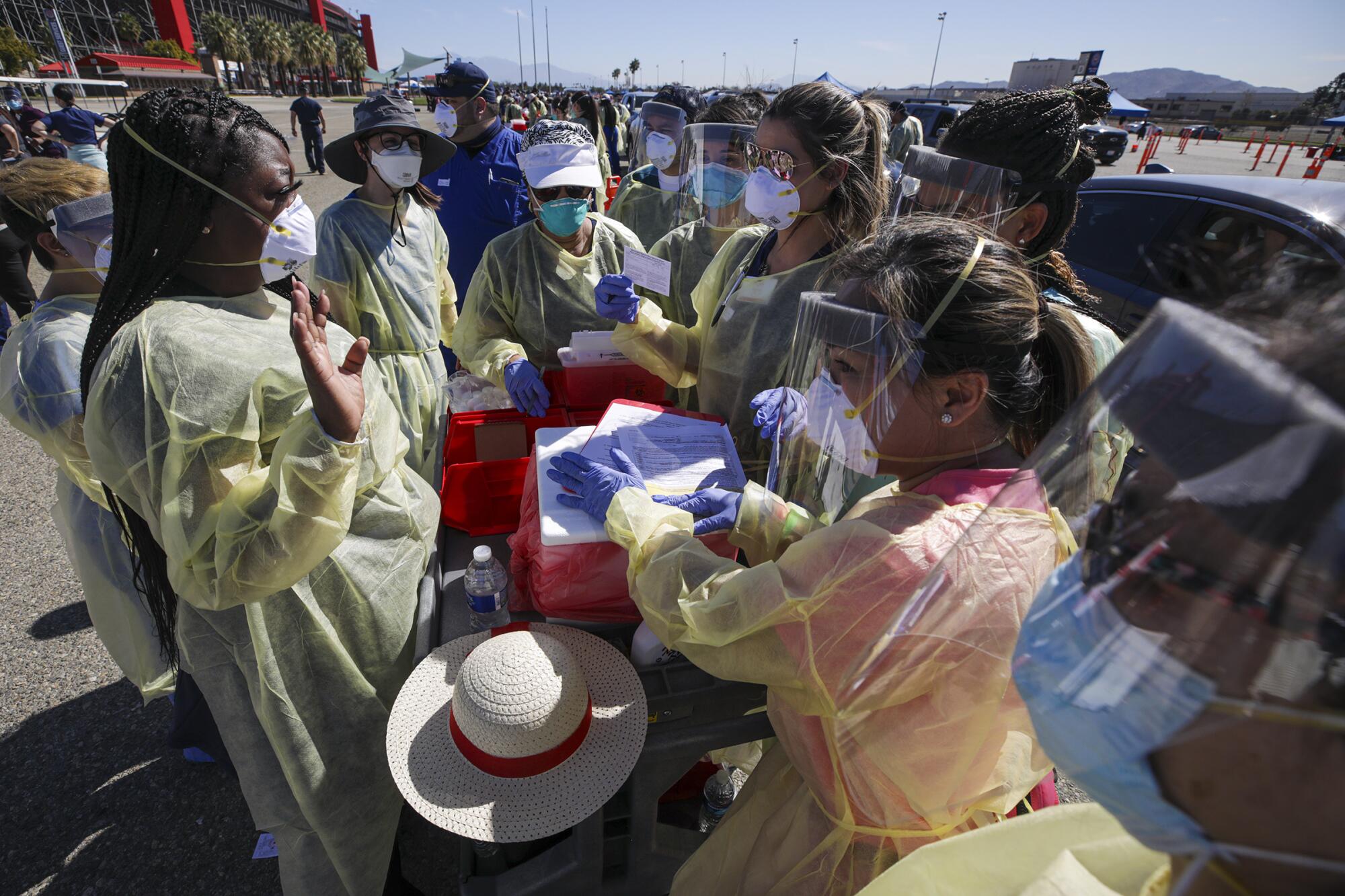 Out of state nurse Leshea Moore, left, helps nurses working first time at a mass vaccination site in Fontana.