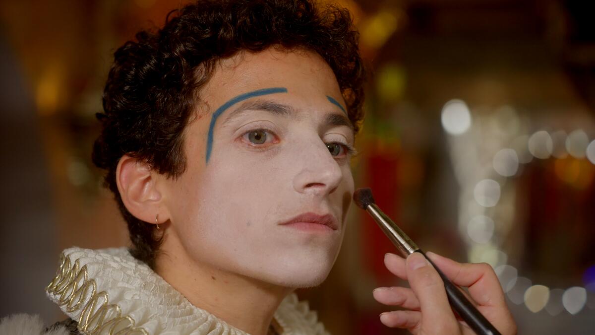 A young man gets his makeup applied.