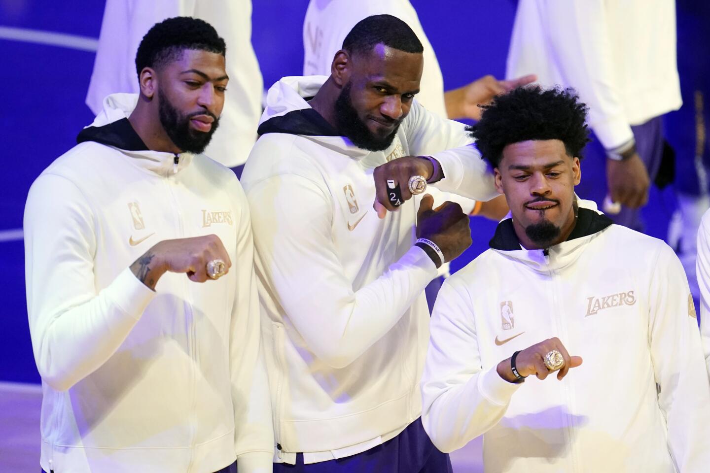 Los Angeles Lakers' Anthony Davis, left, LeBron James, center, and Quinn Cook show their championship rings before the team's NBA basketball game against the Los Angeles Clippers on Tuesday, Dec. 22, 2020, in Los Angeles. (AP Photo/Marcio Jose Sanchez)