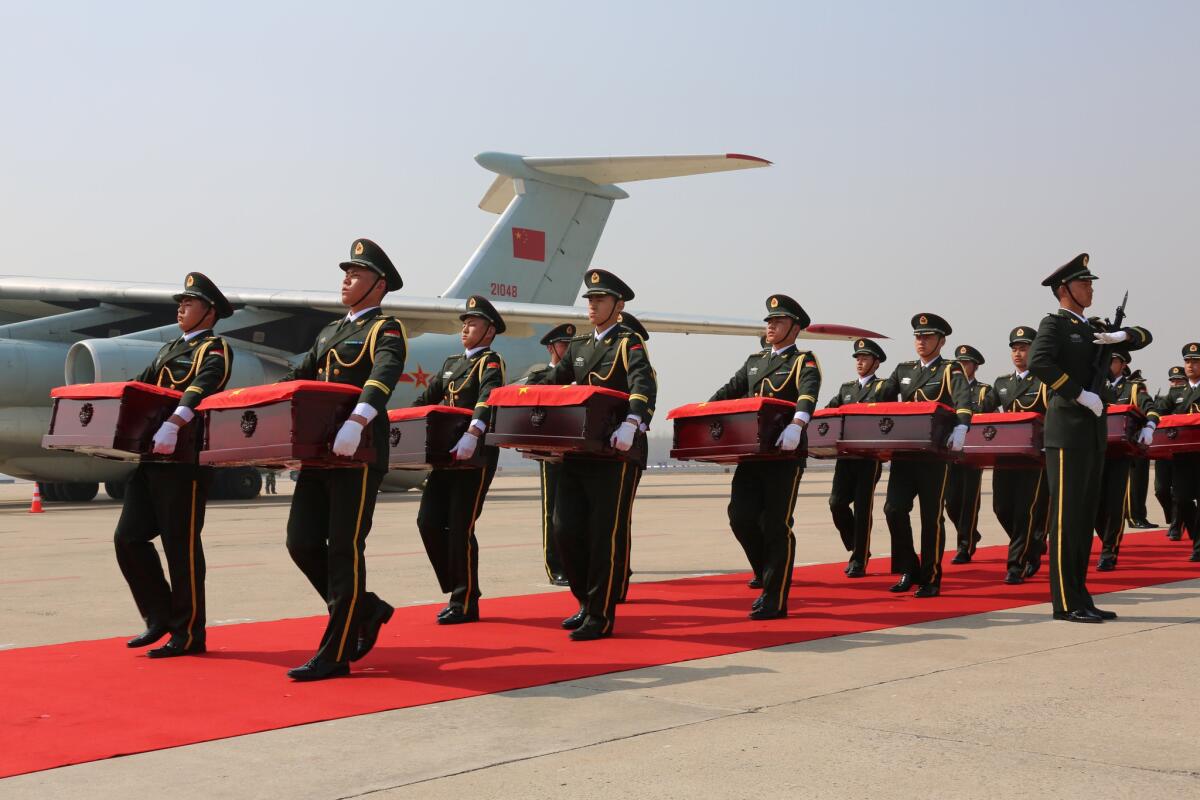 Guards in Shenyang carry caskets containing the remains of 68 Chinese soldiers killed in the Korean War. The remains were transferred from South Korea.