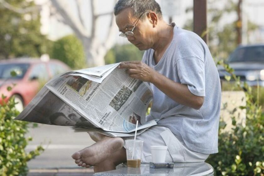 Xuan Nguyen starts his day with a Vietnamese-language paper and iced coffee outside the Asian Garden Mall in Westminster. Little Saigon got its newest daily in July, the fifth to serve Orange County's 150,000 Vietnamese Americans.