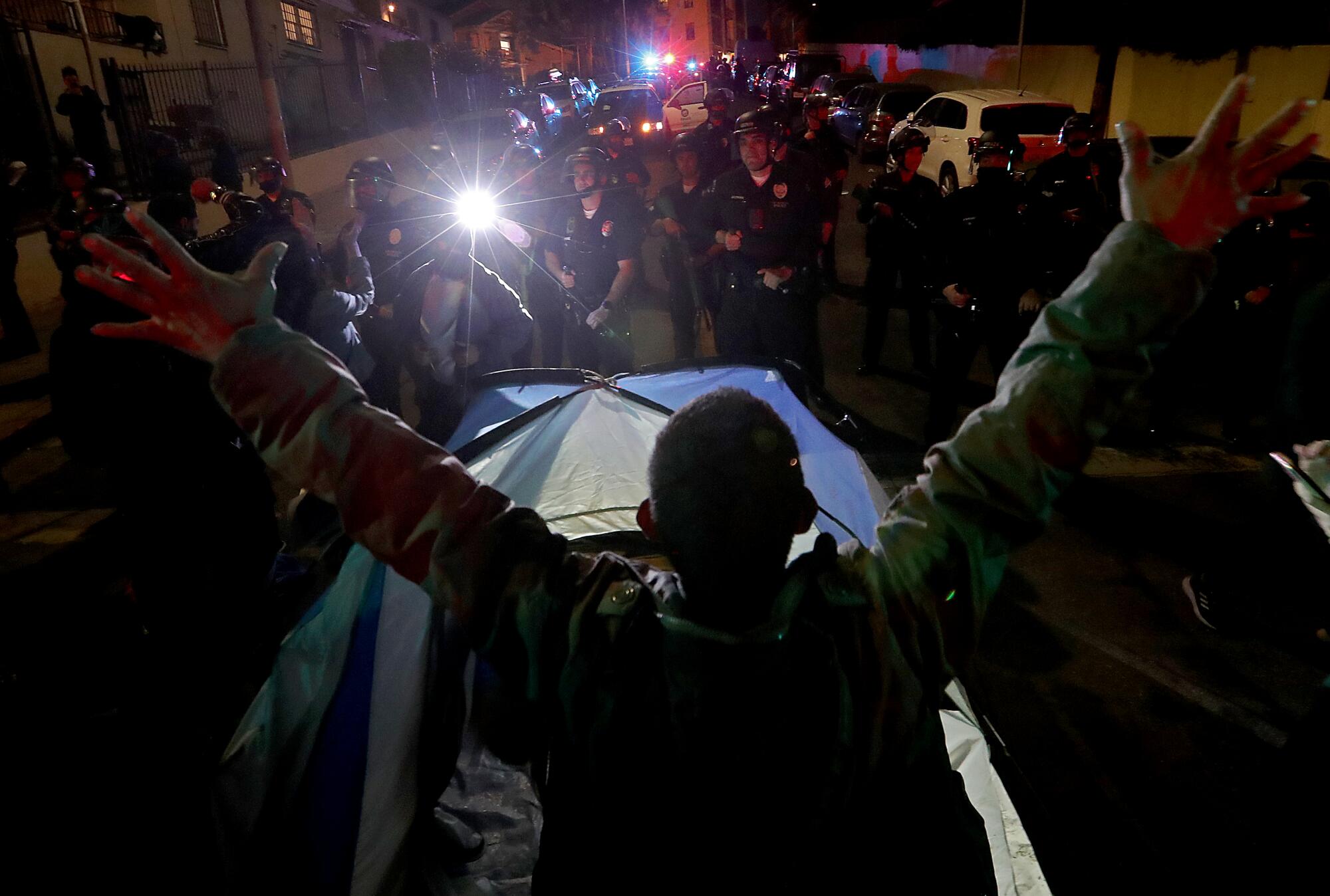 A man stands in front of a tent. 