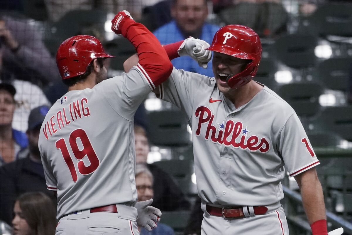 Philadelphia Phillies' Matt Vierling (19) is congratulated by Rhys Hoskins after hitting a go-ahead home run during the ninth inning of the team's baseball game against the Milwaukee Brewers on Tuesday, June 7, 2022, in Milwaukee. (AP Photo/Aaron Gash)