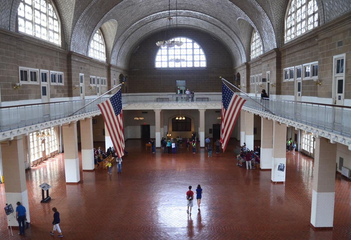 Tourists roam the Great Hall, also known as the Registry Room, at Ellis Island National Museum of Immigration, part of the Statue of Liberty National Monument, N.Y.