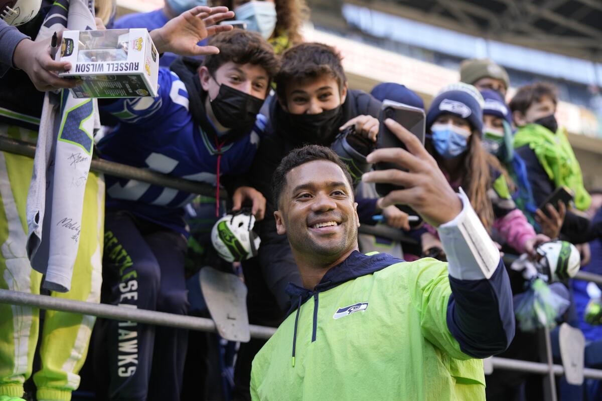 Seattle Seahawks quarterback Russell Wilson poses for a selfie with fans