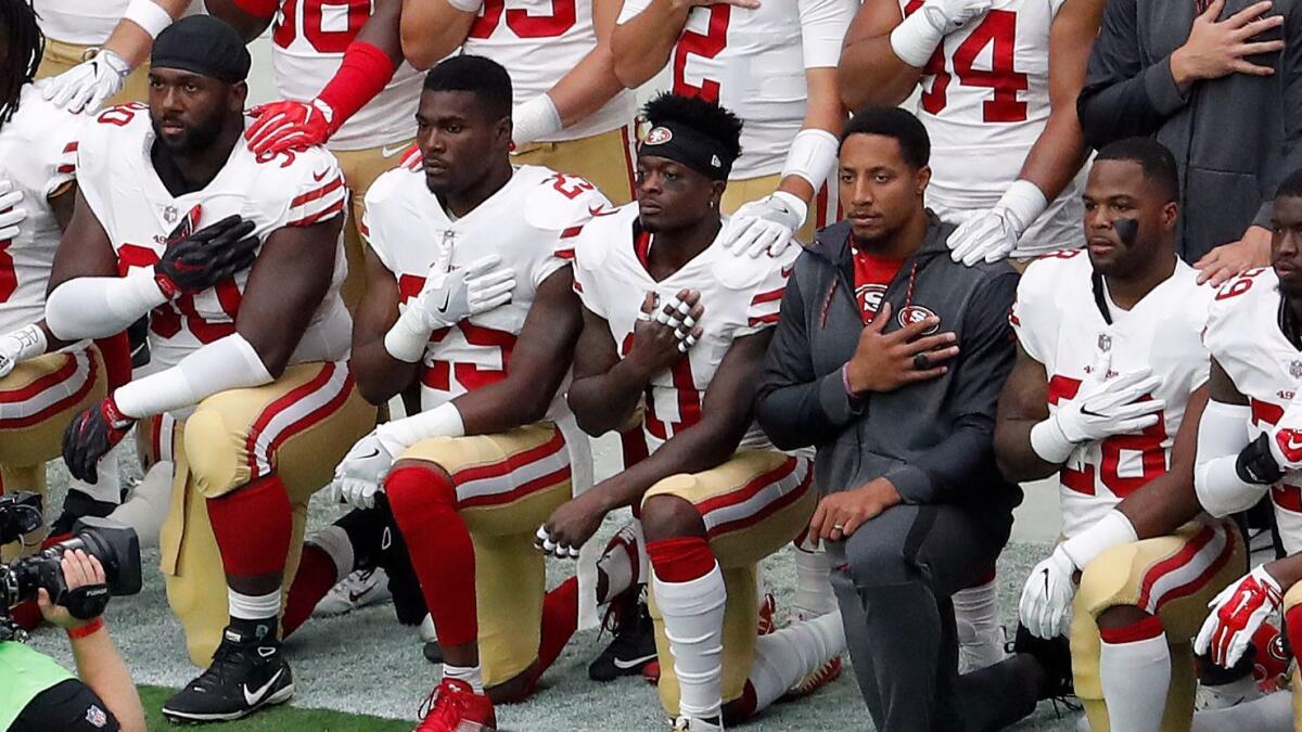 Members of the San Francisco 49ers kneel during the national anthem before an Oct. 1 game against the Arizona Cardinals in Glendale, Ariz.