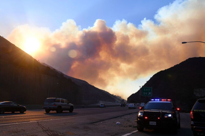 Smoke from the Skirball Fire rises above the 405 freeway near the Bel Aire area of Los Angeles, California, December 6, 2017. / AFP PHOTO / Robyn BeckROBYN BECK/AFP/Getty Images ** OUTS - ELSENT, FPG, CM - OUTS * NM, PH, VA if sourced by CT, LA or MoD **