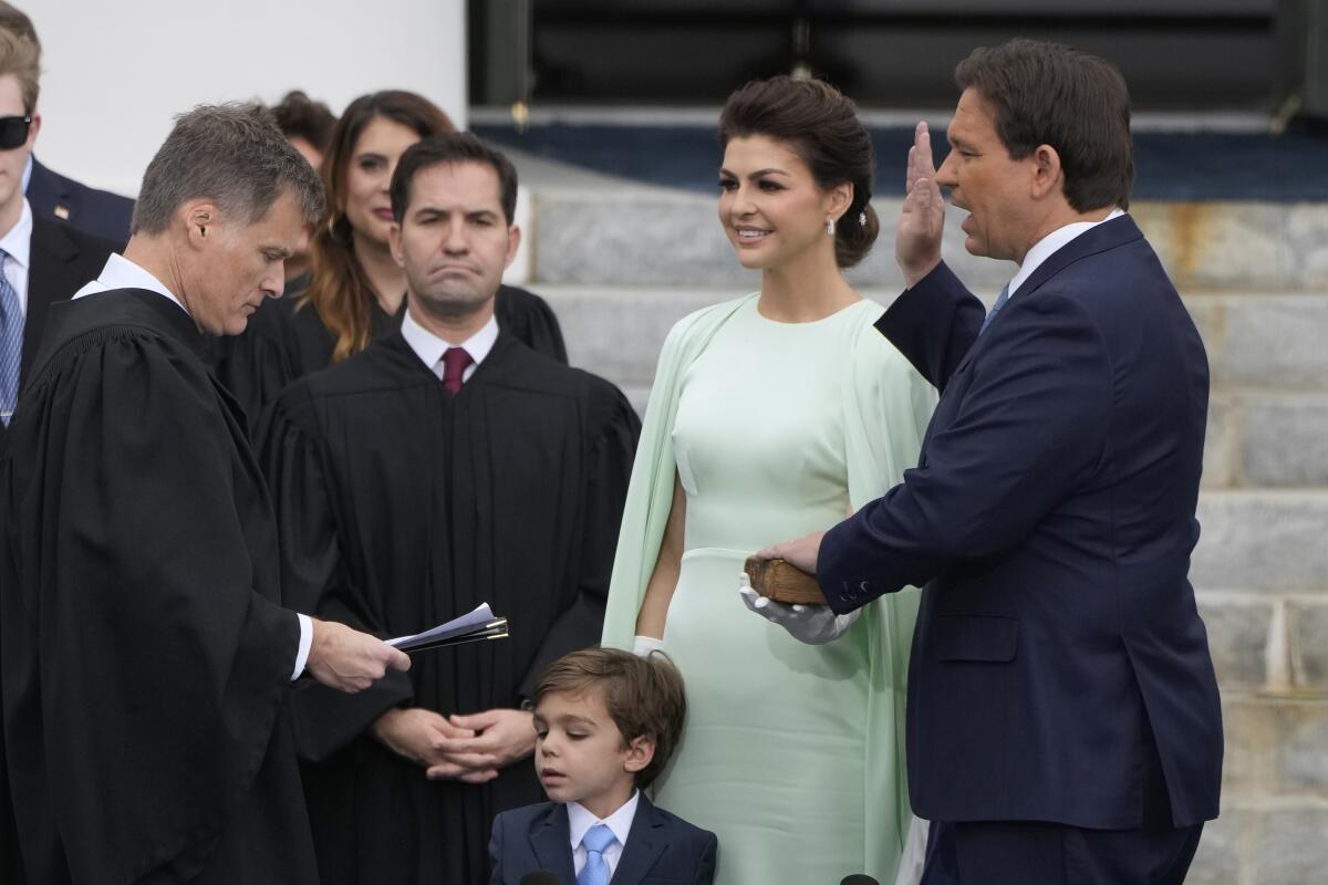 El gobernador de Florida, Ron DeSantis (derecha) presta juramento por el presidente de la Corte Suprema de Florida