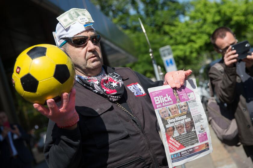 A man pokes fun at FIFA outside the Zurich hotel Baur au Lac, where top officials of world soccer's governing body were arrested on bribery charges.