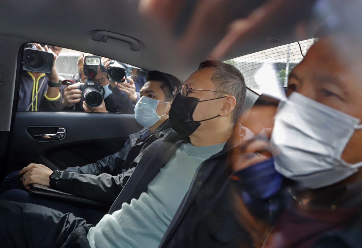 Former law professor Benny Tai sits in a car after being arrested by police in Hong Kong