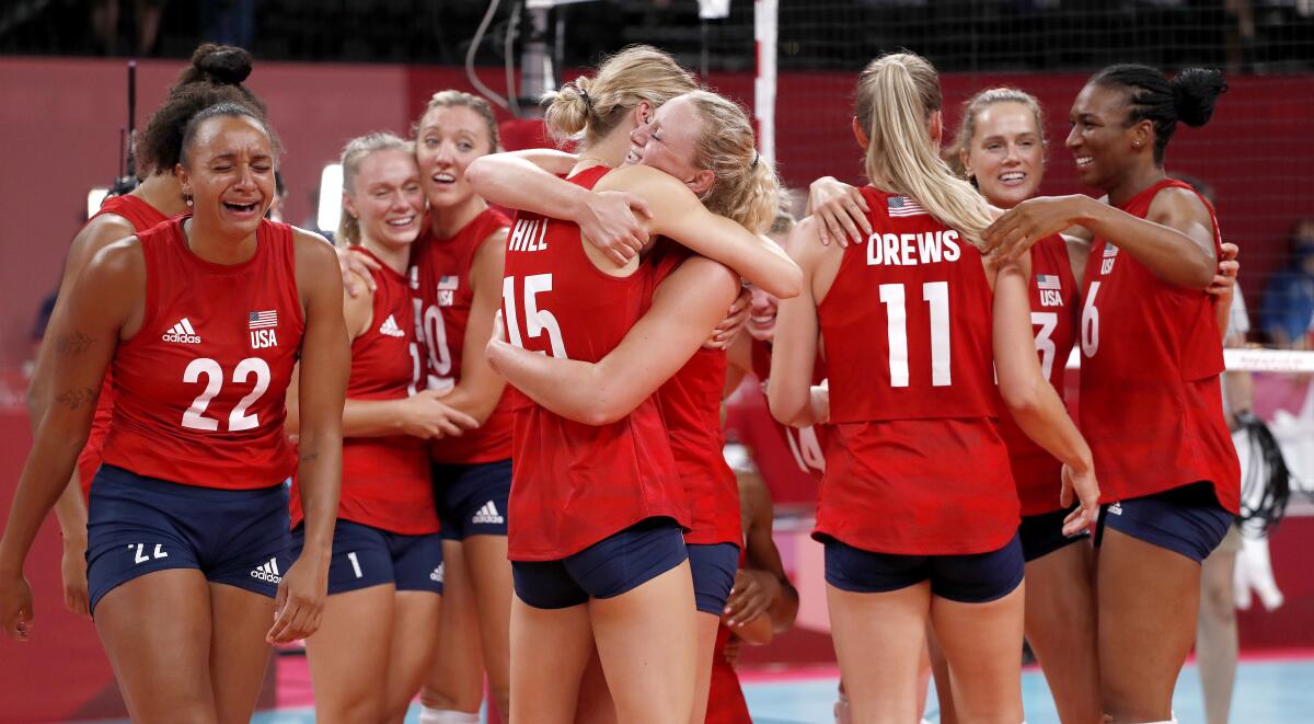 U.S. volleyball teammates hug and cry and smile.