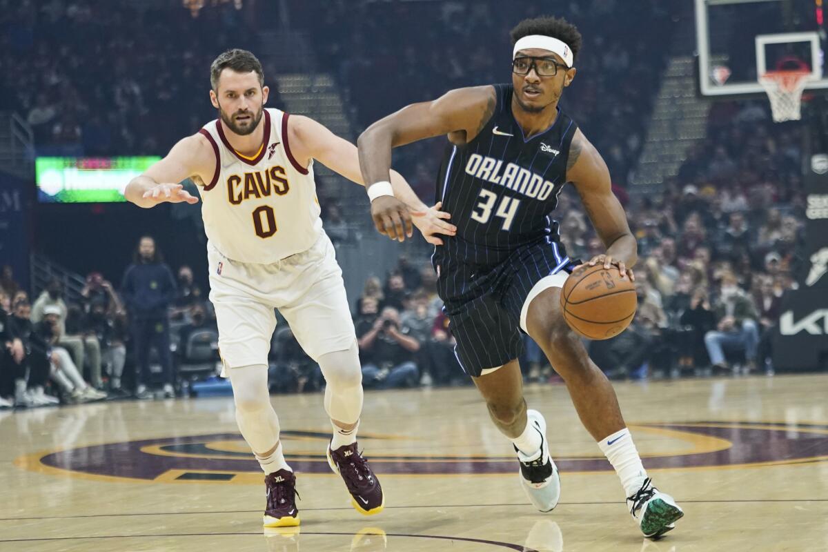 Wendell Carter Jr. del Magic de Orlando avanza hacia la canasta mientras lo defiende Kevin Love 