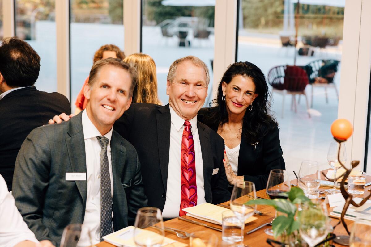 Rich Meyer of JSerra Catholic High, Tony Roberts, vice president of school relations, with OCMA's Lauren Chalmers.
