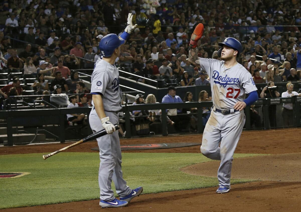 Dodgers' Alex Verdugo (27) celebrates his run scored against the Arizona Diamondbacks with teammate Will Smith during the sixth inning on Tuesday in Phoenix.