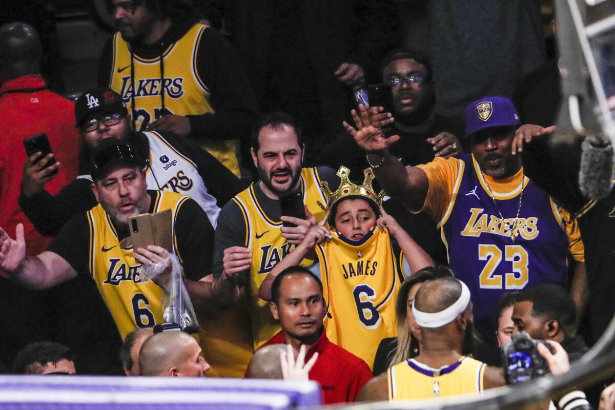 Fans cheer LeBron James and ask for autographs as he leaves the court.