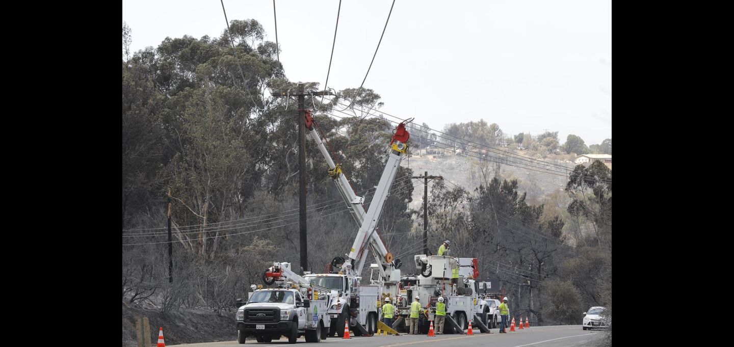 SDG&E crews work along Alpine Boulevard in Alpine to repair the damage caused by the West Fire.