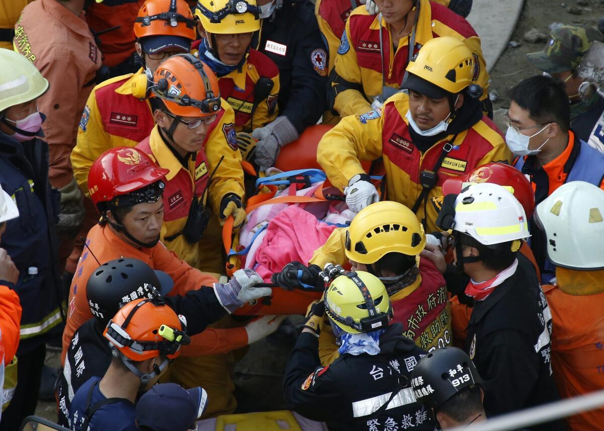 A survivor is carried away after being rescued from a collapsed building following a magnitude 6.4 earthquake Saturday, in Tainan City, southern Taiwan.