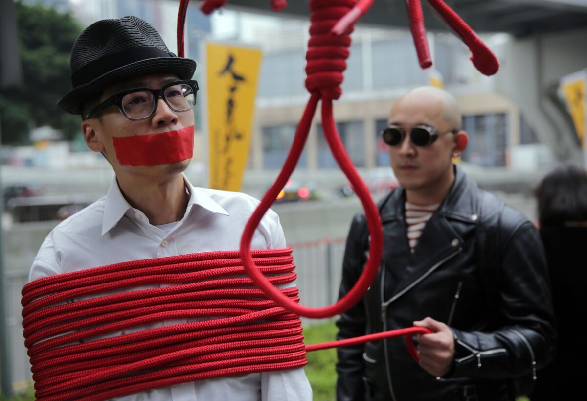 A protester is wrapped up with a rope made into a noose during a Jan. 10 march in Hong Kong calling for the release of missing booksellers from the Mighty Current publishing house.
