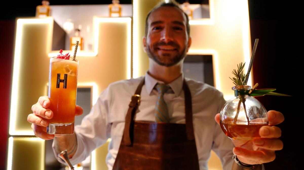 Mixologist Charles Joly holds two of his Oscars Governors Ball cocktail creations: "The Lodge," right, and "The Road Less Traveled."