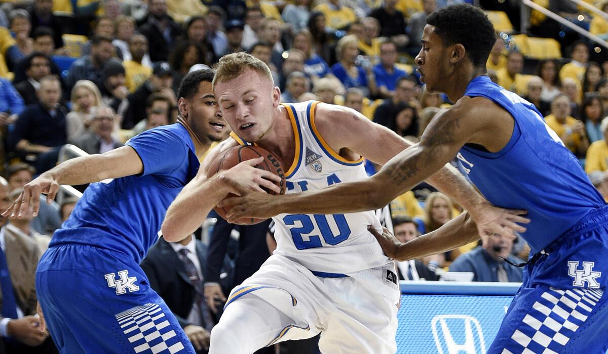 UCLA guard Bryce Alford, center, attempts to move the ball past Kentucky guard Charles Matthews, right, as Jamal Murray, left, helps defend during the first half of a game on Dec. 3.