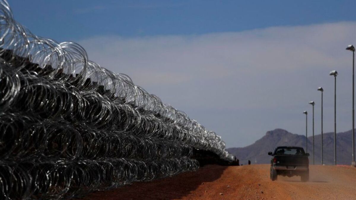 A rancher drives along the border fence separating his property in Cochise County, Ariz., from Mexico.