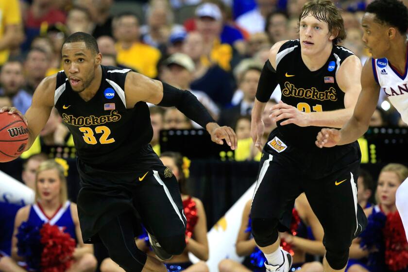 Wichita State guard Tekele Cotton begins a fastbreak against guard Devonte Graham and Kansas in the second half Sunday during the Shockers' 78-65 victory over the Jayhawks on Sunday.