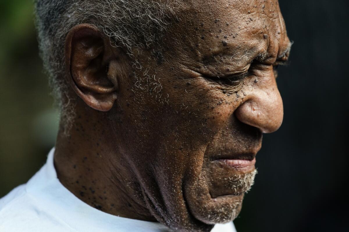 Bill Cosby looks off to the right while wearing a white T-shirt