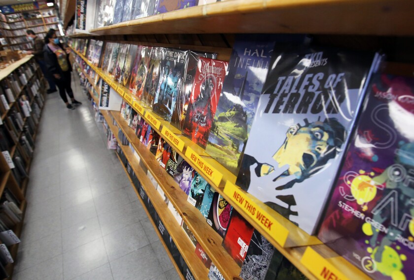 Comic book collectors buy comics from Comics, Toons & Toys in Tustin.