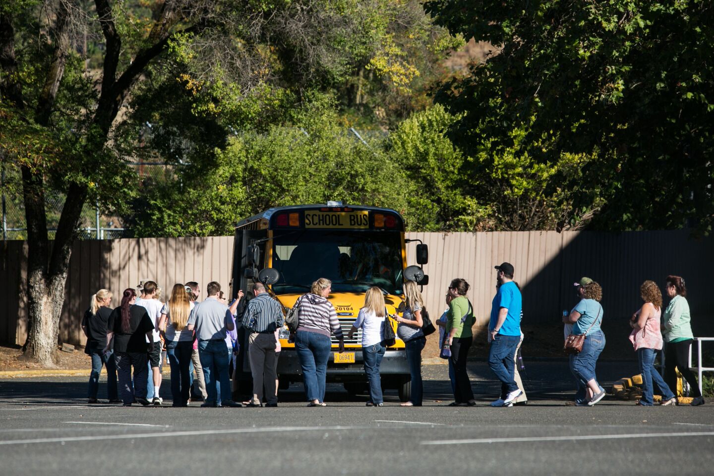 People board buses to retrieve their vehicles at Umpqua Community College after the mass shooting.