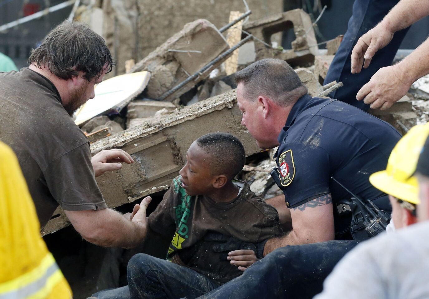 A boy is pulled from beneath a collapsed wall at Plaza Towers Elementary School in Moore, Okla.