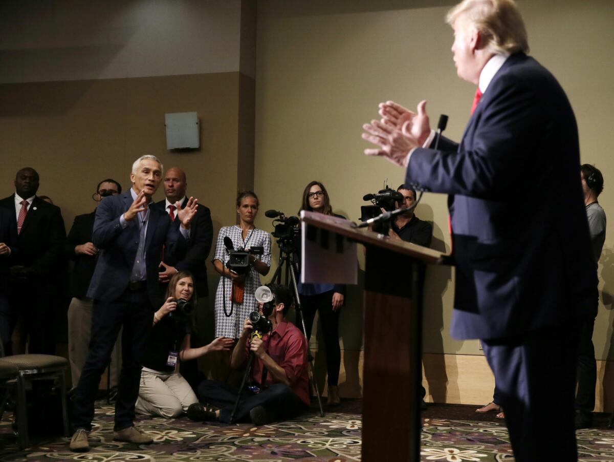 El conductor de Univisión, Jorge Ramos, hace una pregunta al precandidato presidencial republicano, Donald Trump, sobre su propuesta migratoria durante una conferencia de prensa el martes 25 de agosto de 2015 en Dubuque, Iowa. Ramos fue sacado del lugar. (Foto AP/Charlie Neibergall)