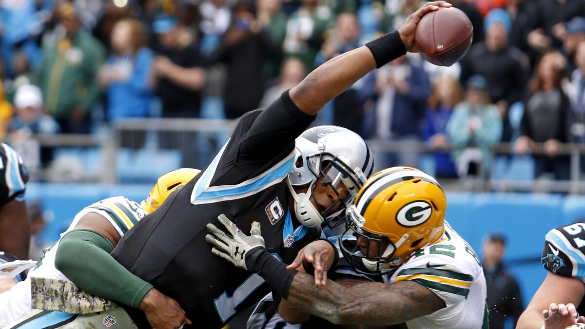 Panthers quarterback Cam Newton reaches the ball over the goal line for a touchdown against the Packers in the first half Sunday.
