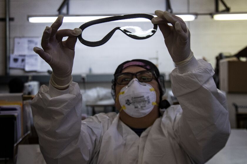 TEMECULA, CA - FEBRUARY 7, 2020: A worker at Paulson's checks for imperfections on a pair of medical goggles assembled for shipment to China to help prevent the spread of the coronavirus on February 7, 2020 in Temecula, California. (Gina Ferazzi/Los AngelesTimes)