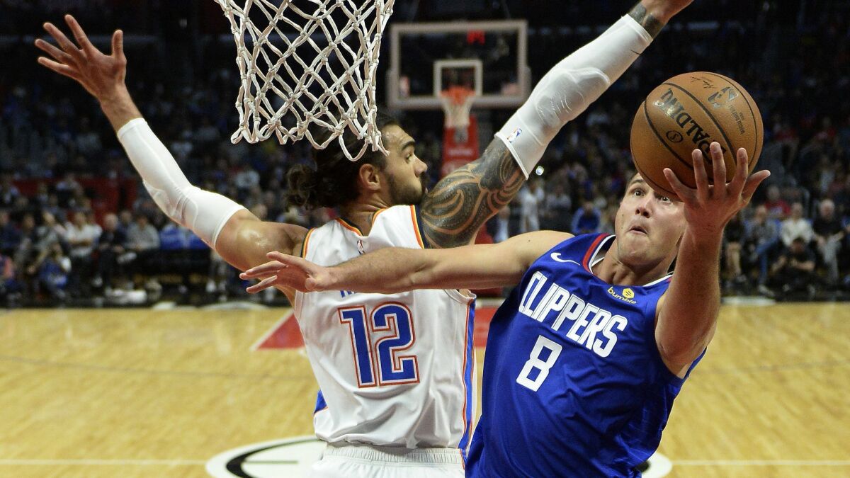 Clippers forward Danilo Gallinari slips past Thunder center Steven Adams for a layup during the second half Friday night.