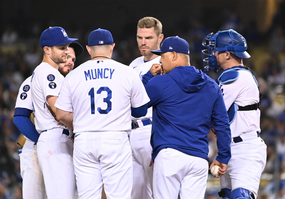 Dodgers manager Dave Roberts talks to players during a game against the Colorado Rockies at Dodger Stadium.