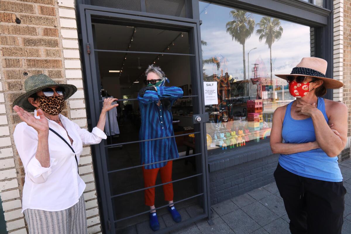 Holly Boies, center, talks with longtime shoppers Enid Koffler, left, and her daughter Samara Koffler on Friday at the entrance of Boies’ store, Salt, on Abbott Kinney Boulevard in Venice. 
