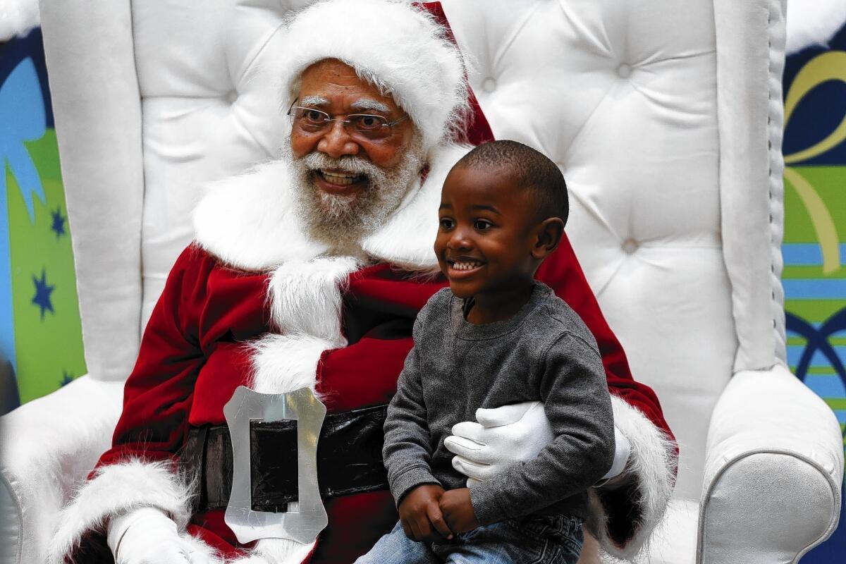 Jahleel Logan, 3, poses with Santa Claus, a.k.a. Langston Patterson, 77, at the Baldwin Hills Crenshaw Plaza. Patterson has been the South L.A. mall's Santa since 2004, with African American families coming at specific times of the day just to visit him. "I just don't want him to think that all greatness comes from a different race," said Jahleel's godmother, Arlene Graves, 45. "There are Santa Clauses his color doing good work too."