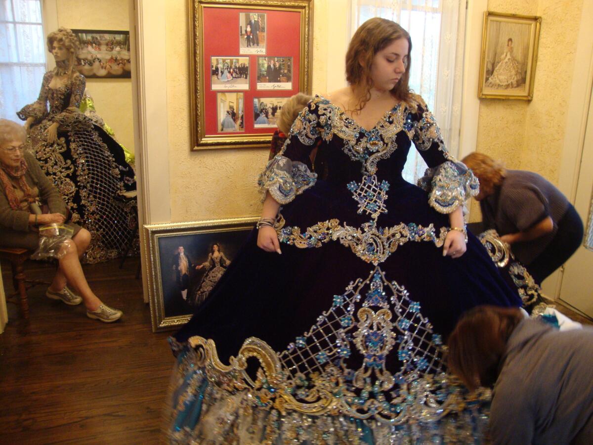 Katie Beckelhymer, a 17-year-old high school senior, is fitted for the gown she will wear at the annual colonial pageant in Laredo, Texas, as her grandmother Anna Haynes, left, looks on.