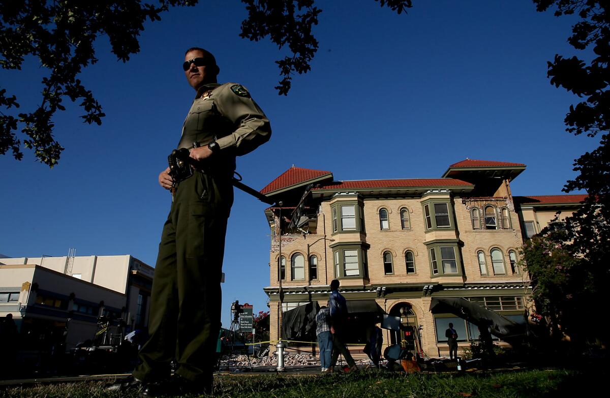 A Napa County sheriff's deputy watches over the damaged Alexandria Square in Napa after an earthquake on Aug. 24, 2014.